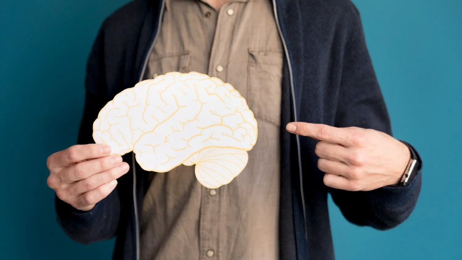 A man holds a paper brain cut-out and points to it
